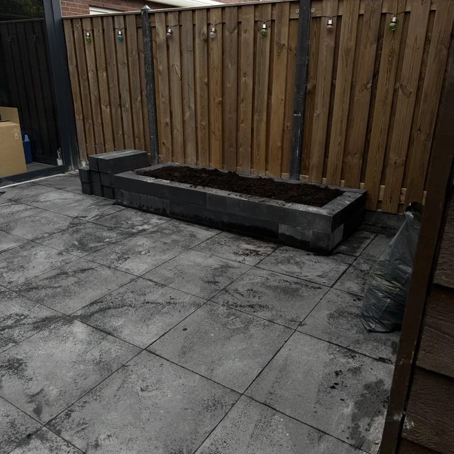 De plantenbak gevuld met grond, bestrating eromheen afgewerkt